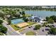 Aerial view of tennis courts and recreational facilities by a lake, highlighting community amenities and parking at 1473 E 130Th Dr, Thornton, CO 80241