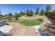 Landscaped backyard with stone retaining wall and walkways, surrounded by mature trees and lush greenery at 11957 S Swift Fox Way, Parker, CO 80134