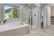 Bright bathroom with a large soaking tub and separate glass-enclosed shower at 11957 S Swift Fox Way, Parker, CO 80134