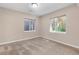 Neutral bedroom featuring carpet flooring and two windows, one overlooking a colorful wooded area at 11957 S Swift Fox Way, Parker, CO 80134