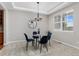 A dining room has modern lighting, four chairs, a round glass table and a decorative mirror at 11957 S Swift Fox Way, Parker, CO 80134