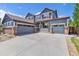 Charming two-story home features a blue exterior, red trim, and an expansive concrete driveway leading to a three-car garage at 11957 S Swift Fox Way, Parker, CO 80134