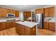Spacious kitchen featuring stainless steel appliances, a center island and warm wood cabinetry at 11957 S Swift Fox Way, Parker, CO 80134