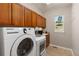 The laundry room includes a modern washer and dryer with ample cabinet space at 11957 S Swift Fox Way, Parker, CO 80134