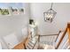 The staircase features wood and white railings, as well as a modern chandelier overhead at 11957 S Swift Fox Way, Parker, CO 80134