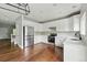 Updated kitchen featuring white cabinetry, stainless steel appliances, and hardwood flooring at 1248 Button Rock Dr, Longmont, CO 80504