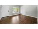 Bright living room with gleaming hardwood floors, a large window, and a white door at 1248 Button Rock Dr, Longmont, CO 80504