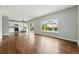 Spacious living room with hardwood floors, large window, and a sliding door to the backyard at 1248 Button Rock Dr, Longmont, CO 80504
