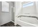 Bright bathroom features a soaking tub with decorative tile surround and a glass-enclosed shower at 56582 E 23Rd Ave, Strasburg, CO 80136