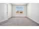 Cozy bedroom with neutral carpet, a large window offering natural light, and a crisp white interior at 56582 E 23Rd Ave, Strasburg, CO 80136