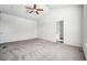 A well lit bedroom with white walls, carpet flooring, ceiling fan and ensuite access at 56582 E 23Rd Ave, Strasburg, CO 80136