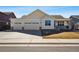 Charming single-Gathering home features a three-car garage and manicured front yard on a sunny day at 56582 E 23Rd Ave, Strasburg, CO 80136