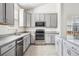 Well-appointed kitchen featuring modern stainless steel appliances and gray cabinets and granite countertops at 56582 E 23Rd Ave, Strasburg, CO 80136