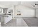 Spacious living room with high ceilings, open to the kitchen, with modern gray cabinets and granite counters at 56582 E 23Rd Ave, Strasburg, CO 80136