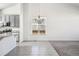 Open-concept living room with tile flooring, a chandelier, and ample natural light from large windows at 56582 E 23Rd Ave, Strasburg, CO 80136