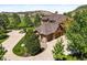 Aerial view of sprawling estate with circular drive, mature landscaping, and a multi-car garage at 9650 S Cougar Rd, Littleton, CO 80127