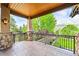 Covered balcony featuring stone pillars, iron railing, and peaceful views at 9650 S Cougar Rd, Littleton, CO 80127