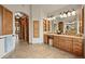 Spacious primary bathroom features double vanity, makeup area, and travertine tile flooring at 9650 S Cougar Rd, Littleton, CO 80127