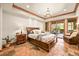 Bedroom featuring a king-size bed, wood trim, a chandelier, and access to a private outdoor patio at 9650 S Cougar Rd, Littleton, CO 80127