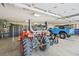 Well-equipped garage with storage cabinets, tractor, and blue Bronco, perfect for vehicle enthusiasts at 9650 S Cougar Rd, Littleton, CO 80127