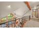 Upper hallway with decorative wrought iron railing overlooks the living room and floor to ceiling windows at 9650 S Cougar Rd, Littleton, CO 80127