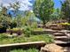 Multi-tiered landscaping with stone walls, steps, and a variety of plants at 9650 S Cougar Rd, Littleton, CO 80127