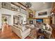 Spacious living room with stone fireplace, wood floors, and large windows at 9650 S Cougar Rd, Littleton, CO 80127