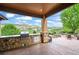 Covered outdoor patio area with built-in grill and stone accents at 9650 S Cougar Rd, Littleton, CO 80127