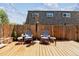 Outdoor backyard with a wood fence, cozy seating, and an open backyard deck at 11402 W 17Th Pl, Lakewood, CO 80215