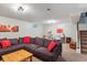 Finished basement features comfortable lounge area with plush sectional sofa and nearby stairs at 11402 W 17Th Pl, Lakewood, CO 80215