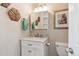 Charming bathroom vanity with marble countertop, framed mirror, decorative wall art and lighting fixture above sink at 11402 W 17Th Pl, Lakewood, CO 80215