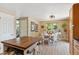 Open dining area featuring wood floors, a white table and chairs, and access to other living spaces at 11402 W 17Th Pl, Lakewood, CO 80215