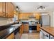 Bright kitchen featuring stainless steel appliances, wooden cabinets, granite countertops and hardwood floors at 11402 W 17Th Pl, Lakewood, CO 80215