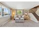 Bright living room featuring large windows, neutral decor, plush carpet, and a cozy seating area at 11402 W 17Th Pl, Lakewood, CO 80215