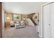 Cozy living room featuring neutral tones, plush carpeting, and staircase access at 11402 W 17Th Pl, Lakewood, CO 80215