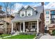 Charming brick home with a covered front porch, columns, and beautifully landscaped front yard at 1730 N Gaylord St, Denver, CO 80206