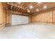 Spacious unfinished garage with exposed wood beams, a concrete floor, and an overhead door at 1730 N Gaylord St, Denver, CO 80206