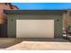 Detached garage with exterior lighting and an overhead door and adjacent parking area at 1730 N Gaylord St, Denver, CO 80206