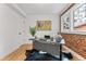 Bright home office with modern desk, wood floors, and exposed brick detail around the window at 1730 N Gaylord St, Denver, CO 80206