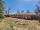 Spacious backyard with a mix of grass and dry patches, bordered by a wooden fence at 4291 W Wagon Trail Dr, Littleton, CO 80123