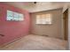 Bedroom featuring pink and white walls, two windows, and damaged walls and floors at 4291 W Wagon Trail Dr, Littleton, CO 80123