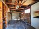 Unfinished garage with exposed wood beams and a window providing natural light at 4291 W Wagon Trail Dr, Littleton, CO 80123