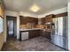 Kitchen with stainless steel appliances, dated cabinetry, and worn flooring at 4291 W Wagon Trail Dr, Littleton, CO 80123