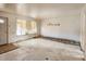 Living room showcasing a ladder, window, and damaged walls and floors at 4291 W Wagon Trail Dr, Littleton, CO 80123