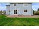 Home's backyard showing a stone patio, lawn, and sliding glass doors at 650 Olympia Ave, Longmont, CO 80504