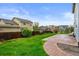 A spacious backyard featuring green grass, a stone patio and wood fence at 650 Olympia Ave, Longmont, CO 80504