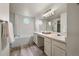 Bright bathroom featuring a soaking tub, double sinks, and modern fixtures at 650 Olympia Ave, Longmont, CO 80504