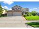 Stunning two-story home with a brick-accented three-car garage and a charming covered front porch, set on a lush green lawn at 650 Olympia Ave, Longmont, CO 80504