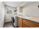 Functional laundry room featuring a modern washer/dryer, utility sink, and ample counter space for convenience at 650 Olympia Ave, Longmont, CO 80504