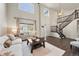 Spacious living room with tall windows, hardwood floors, and an open staircase at 650 Olympia Ave, Longmont, CO 80504
